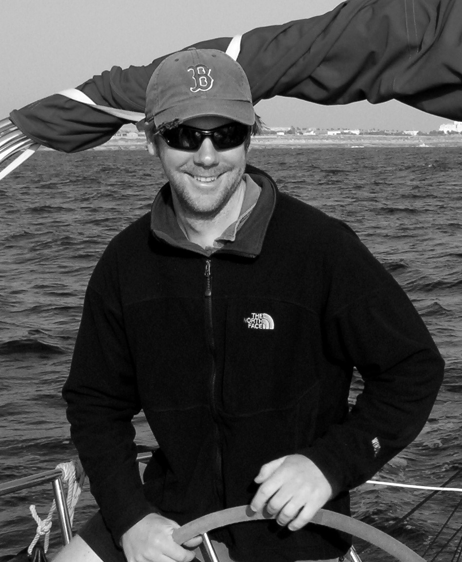Jason Angelus at the helm of a sailing boat